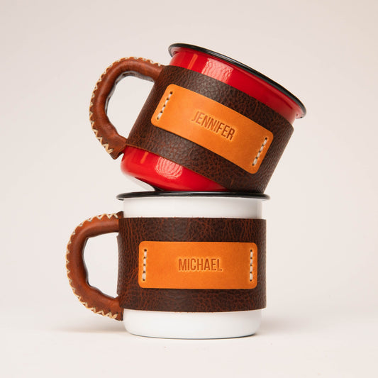 Personalized enamel camp mugs with stamped leather sleeves for a corporate event