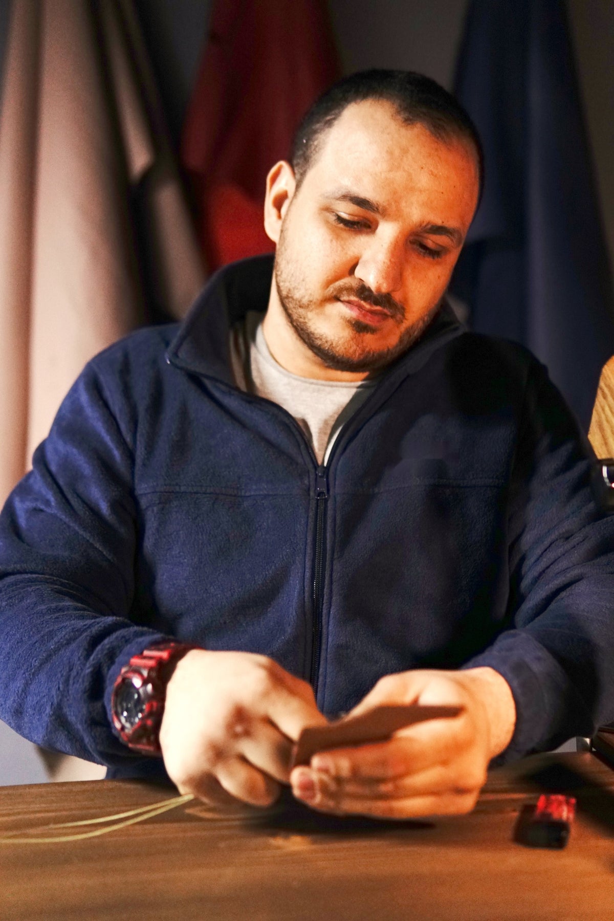 Mus hand-stitching a leather piece at the MUSS workbench